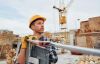 Contractor standing at a construction site with tools